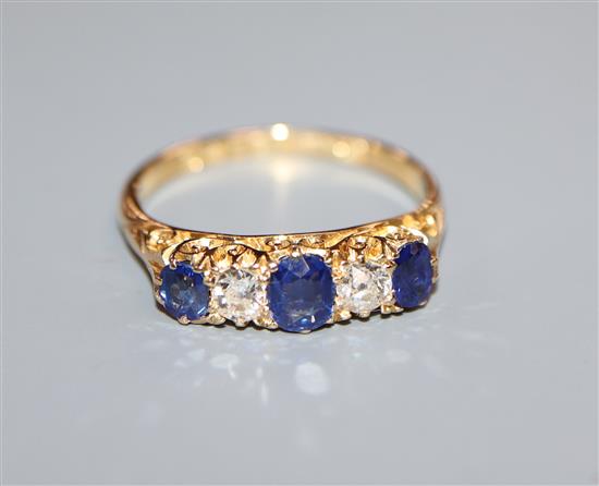 An early 20th century 18ct gold two stone diamond and three stone sapphire half hoop ring, size N.